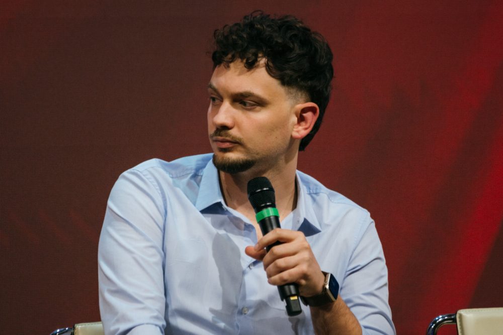 Raffaele Bottone seduto con il microfono durante un panel
